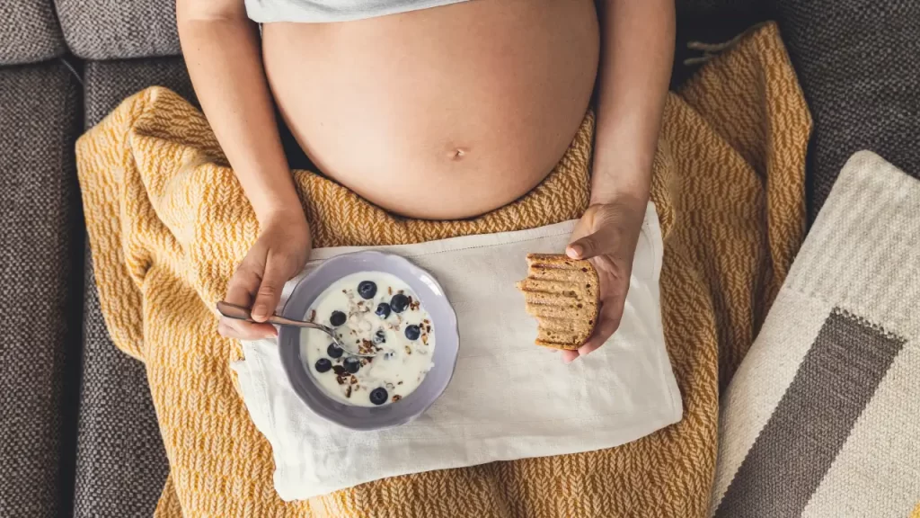 gestante comendo iogurte com frutas