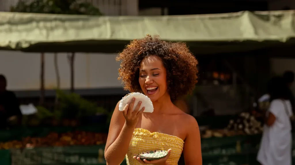 mulher sorrindo comendo tapioca