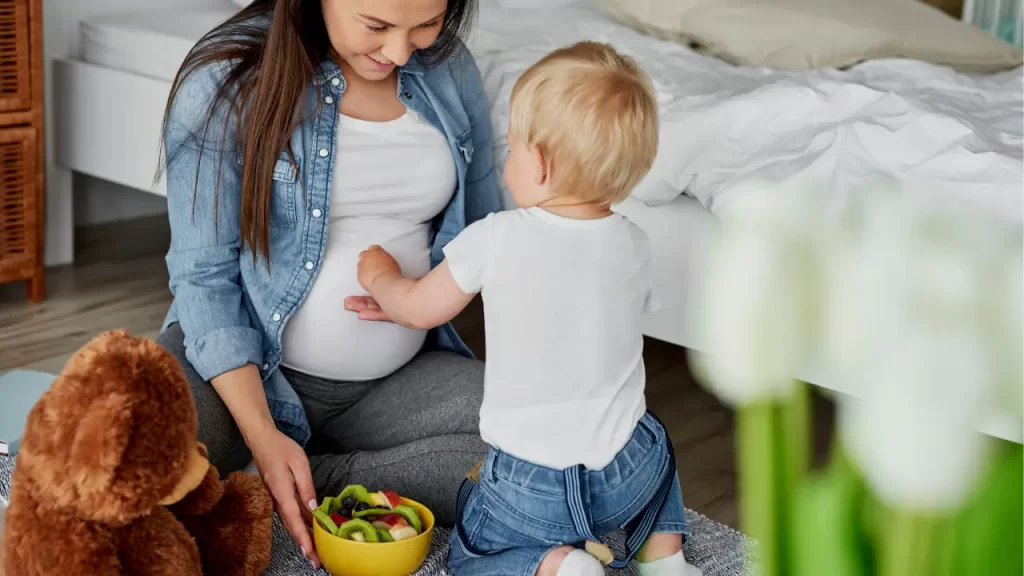 gestante com primeiro filho comendo frutas