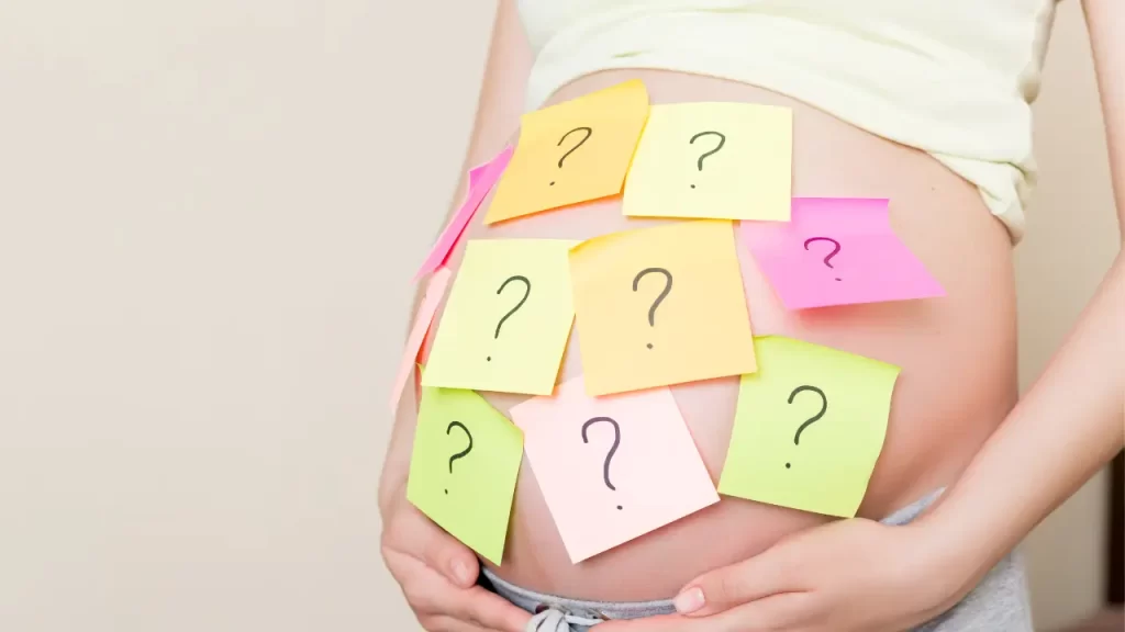 barriga de gestante com post its coloridos com pontos de interrogação