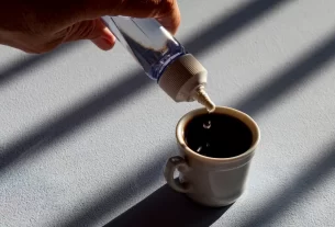 adoçante sendo colocado em uma xícara de café
