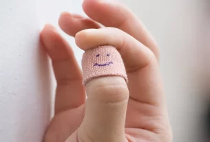 polegar com curativo desenhado com uma carinha