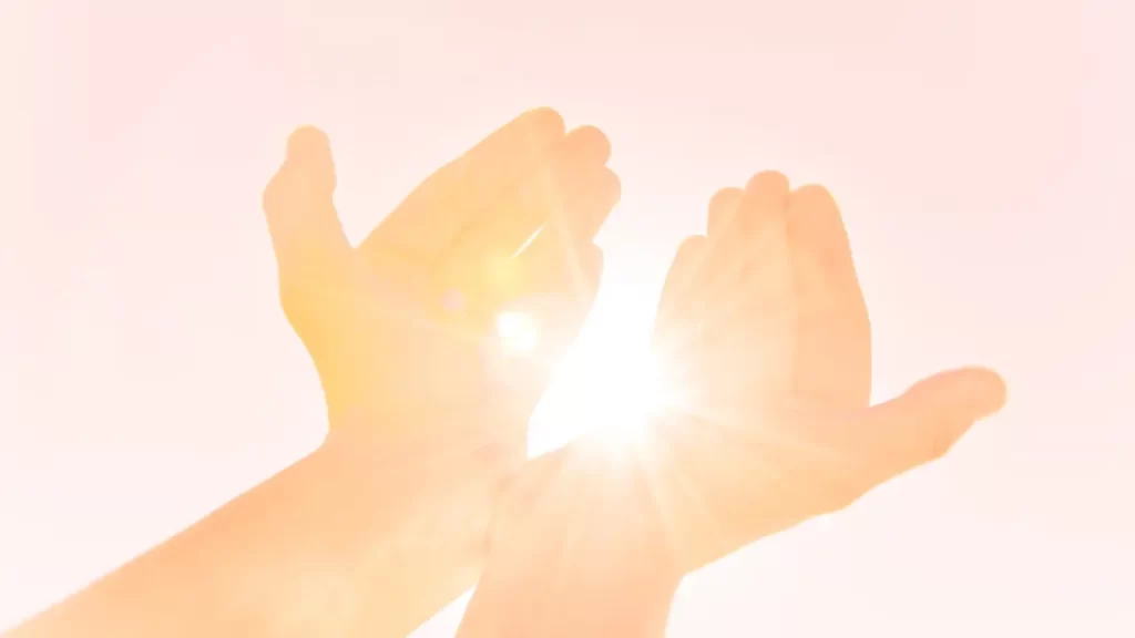 mãos com sol por trás