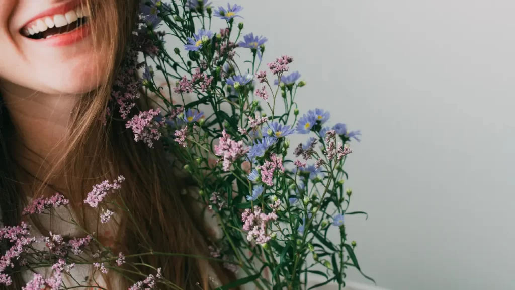 mulher sorrindo segurando flores