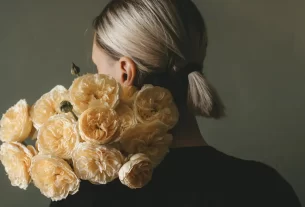 mulher de costas segurando um buque de rosas