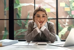 mulher com feição de preocupada na mesa de trabalho
