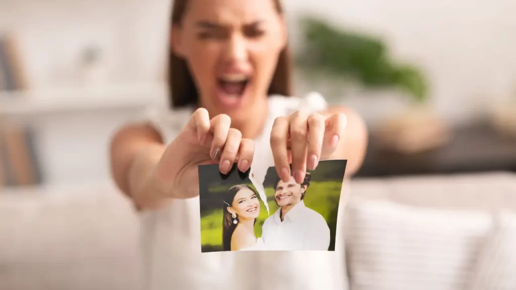 mulher rasgando uma foto de um casal