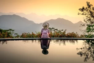 mulher olhando a natureza próxima a uma piscina, sabendo Como Lidar com Solidão aos 50 Anos Sendo Solteira
