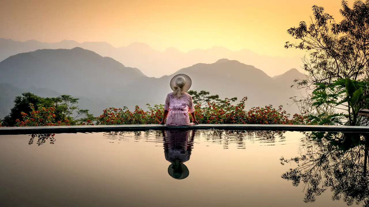 mulher olhando a natureza próxima a uma piscina, sabendo Como Lidar com Solidão aos 50 Anos Sendo Solteira