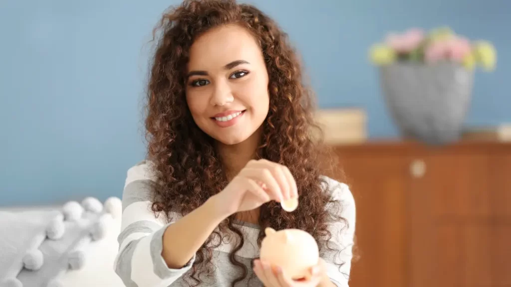 Mulher poupando dinheiro após cortar gastos mantendo qualidade de vida