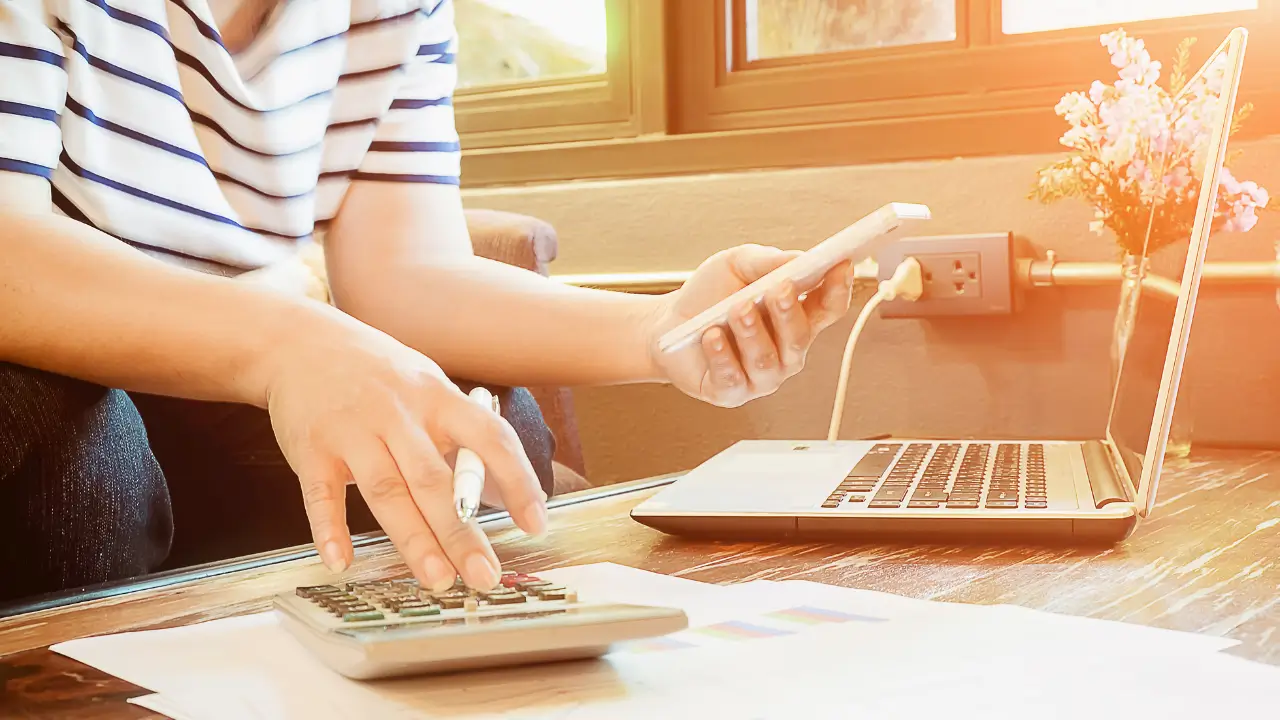 Mulher madura organizando orçamento doméstico para cortar gastos sem perder conforto