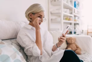 Mulher madura verificando perfil em app de relacionamento com cautela