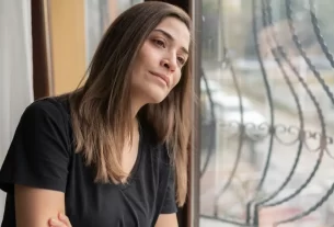 Imagem de uma mulher de meia-idade em momento contemplativo, transmitindo introspecção e força