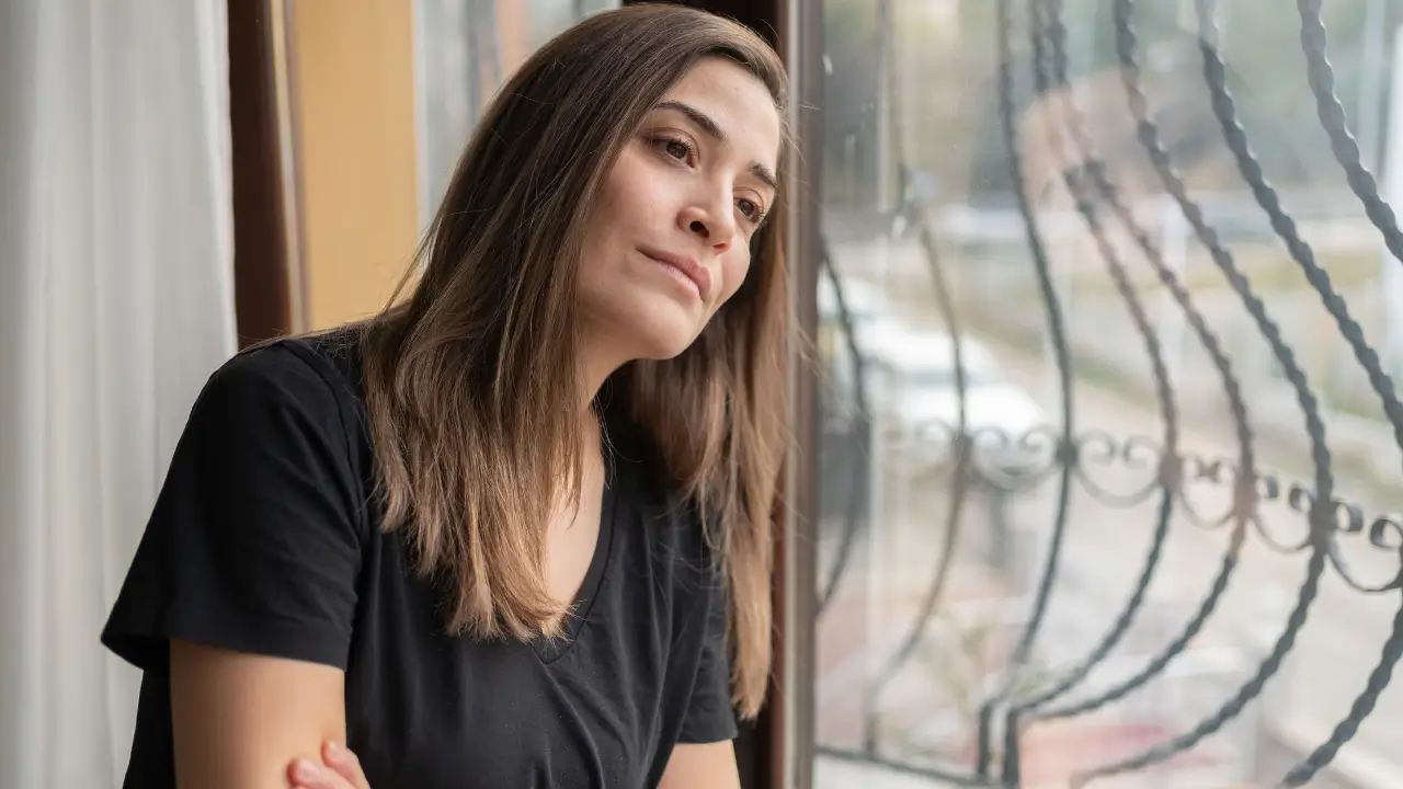 Imagem de uma mulher de meia-idade em momento contemplativo, transmitindo introspecção e força