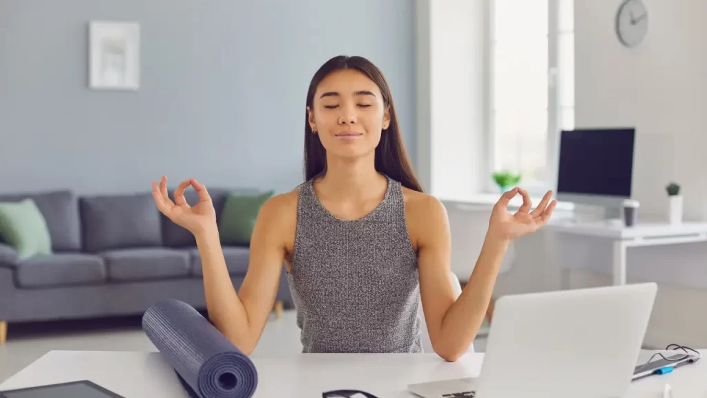 mulher meditando durante o trabalho em uma micropausa