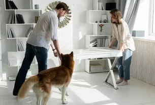 Casal reorganizando móveis da sala para transformar ambiente e vida