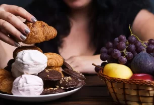 Mulher na menopausa em dúvida entre comer frutas ou doces