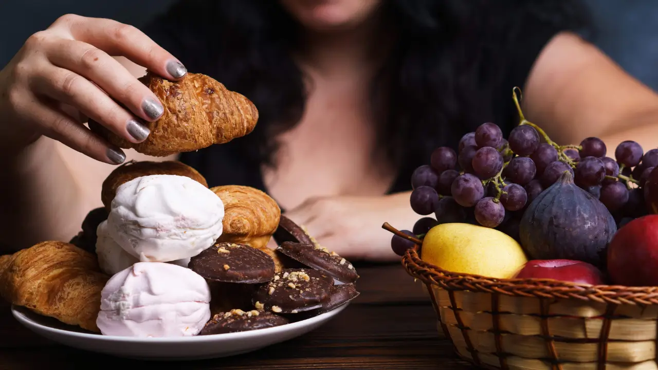Mulher na menopausa em dúvida entre comer frutas ou doces