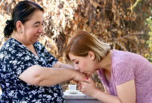 Mulher honrando sua mãe, beijando sua mão