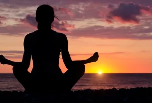Mulher madura praticando mindfulness ao amanhecer para regular relógio biológico e prevenir envelhecimento precoce