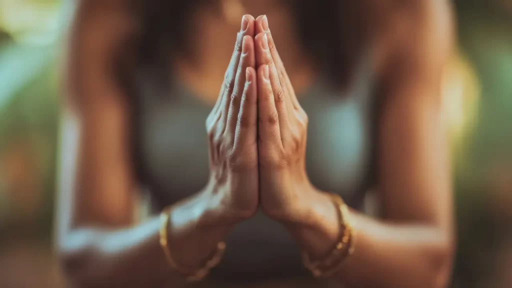Mãos femininas em posição de oração com luz suave simbolizando conexão espiritual