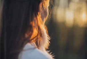 Mulher de 40 anos em momento de oração silenciosa em ambiente tranquilo com luz natural