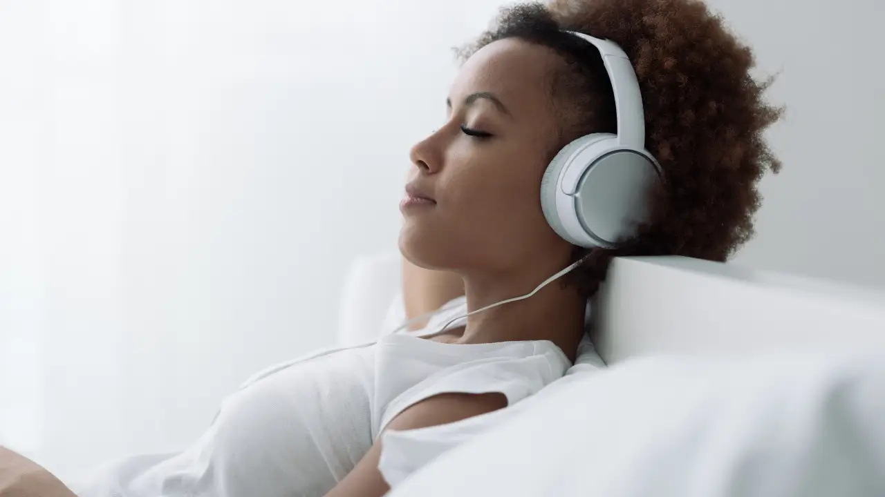 Mulher praticando escuta consciente de músicas de alta vibração para bem-estar emocional