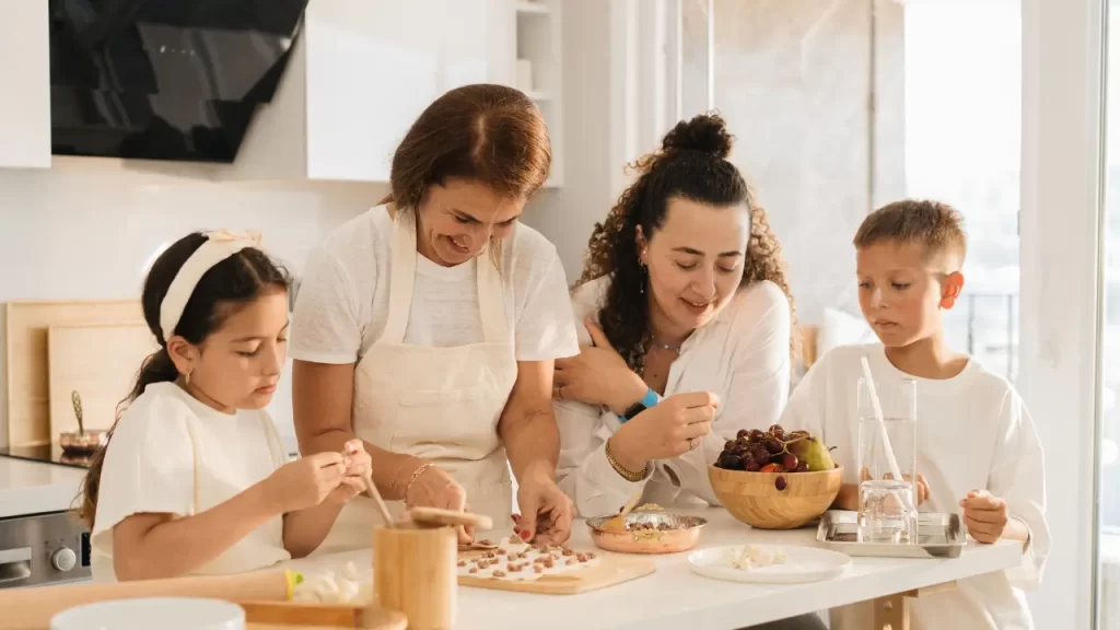 Três gerações cozinhando juntas demonstrando harmonia familiar