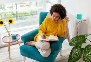 Mulher de 45 anos escrevendo à mão em diário, demonstrando concentração e bem-estar 