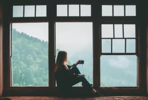 Mulher refletindo sobre a culpa de descansar em momento de pausa