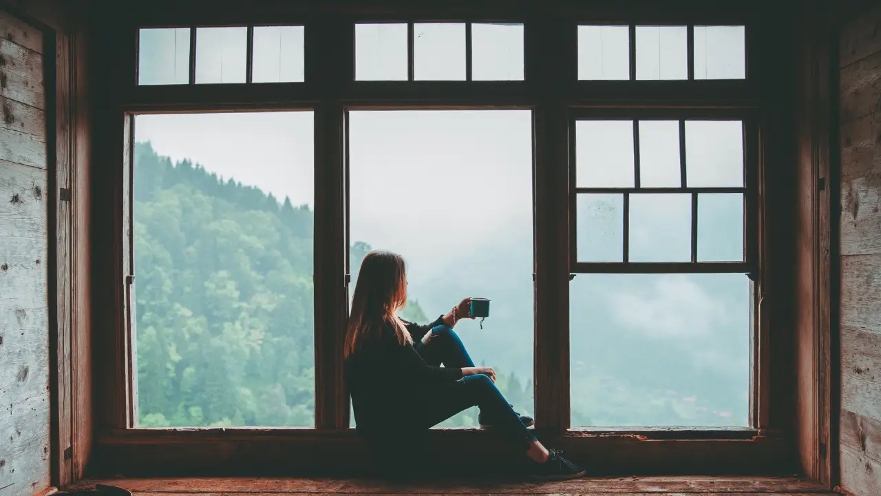Mulher refletindo sobre a culpa de descansar em momento de pausa