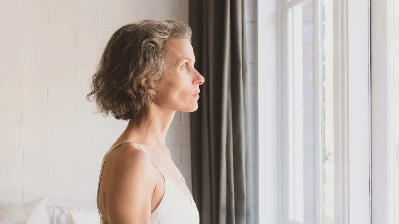 Mulher de 45 anos refletindo sobre por que o autoperdão é mais difícil