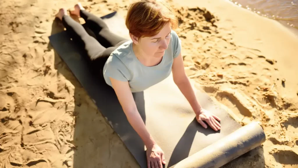 Mulher madura praticando yoga ao ar livre, demonstrando bem-estar e controle sobre sua saúde após compreender seu diagnóstico