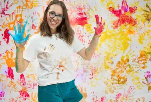 mulher toda suja de tinta mostrando que brincar ainda faz bem depois dos 40