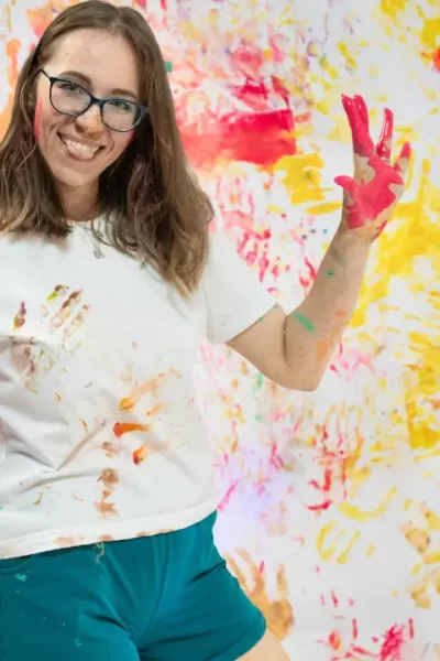 mulher toda suja de tinta mostrando que brincar ainda faz bem depois dos 40