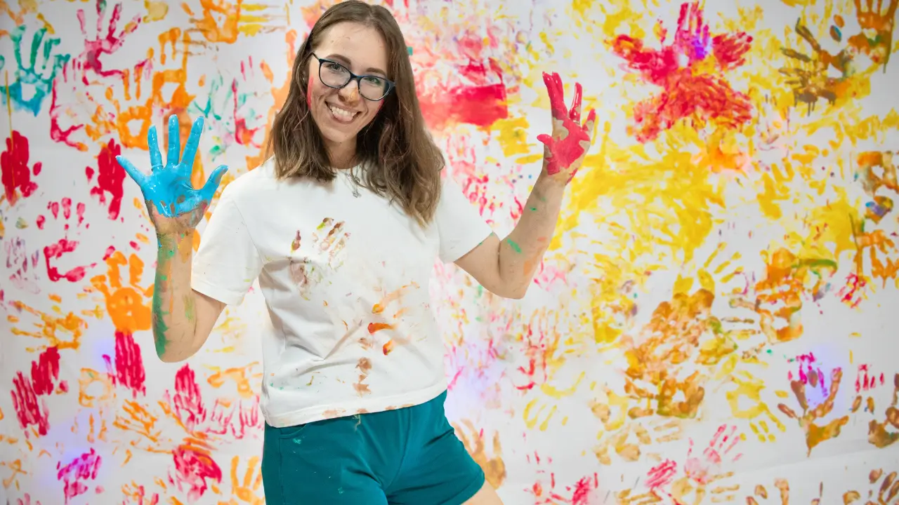 mulher toda suja de tinta mostrando que brincar ainda faz bem depois dos 40