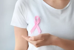 Mulher com o símbolo da campanha de câncer de mama